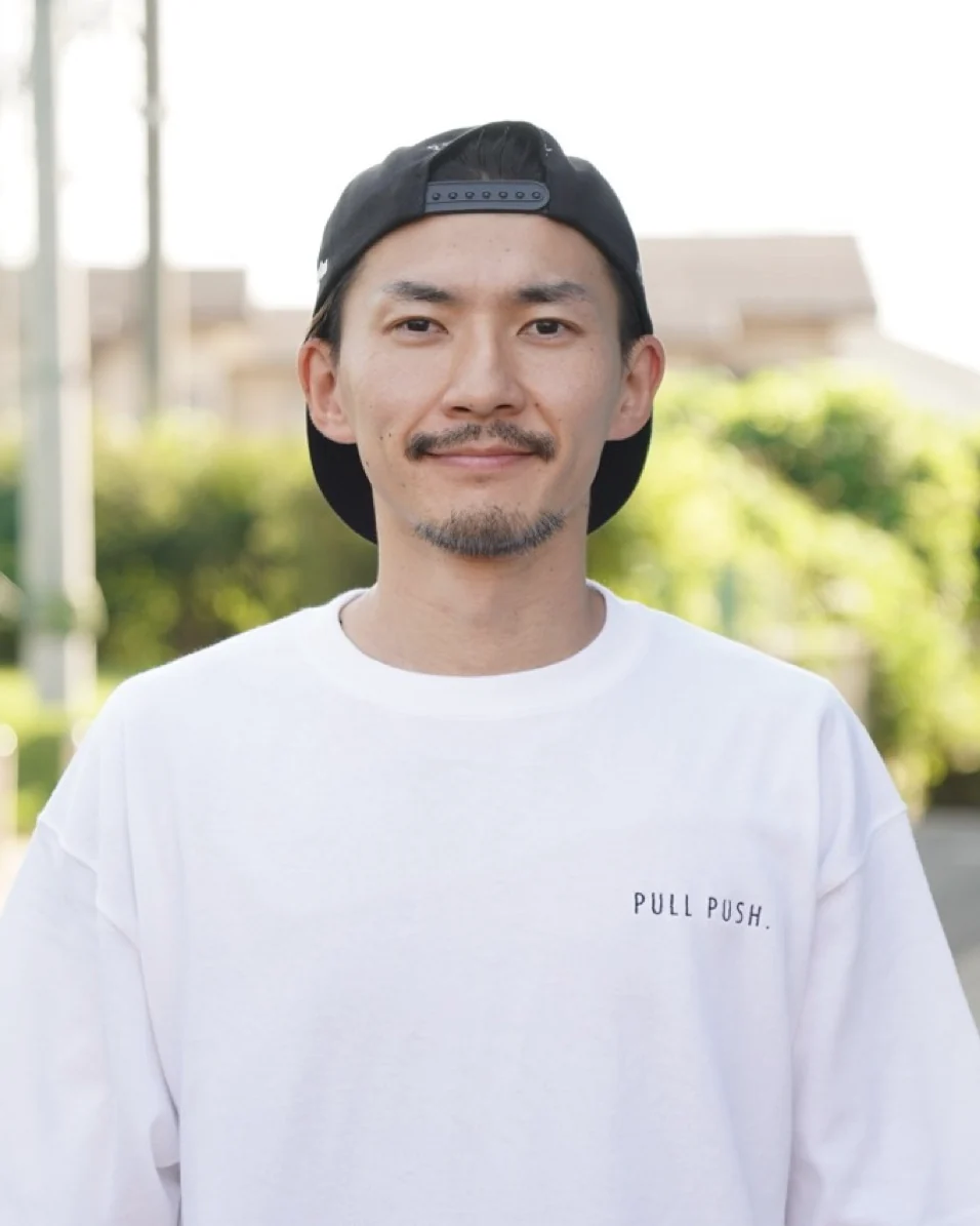 自然光の中で穏やかな表情を見せる石関聖